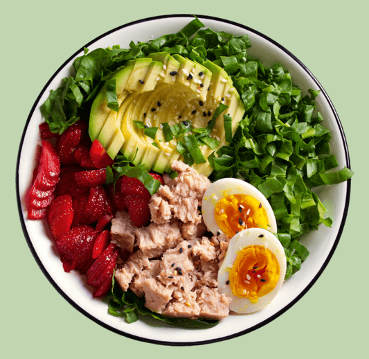 Picture of tuna in a salad bowl with avocado, softboiled eggs, kale and strawberries